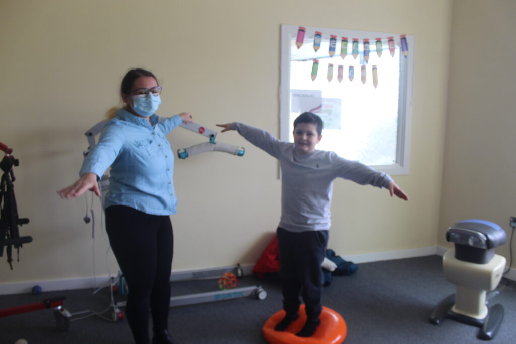 A mother and son are balancing on red squishy rings