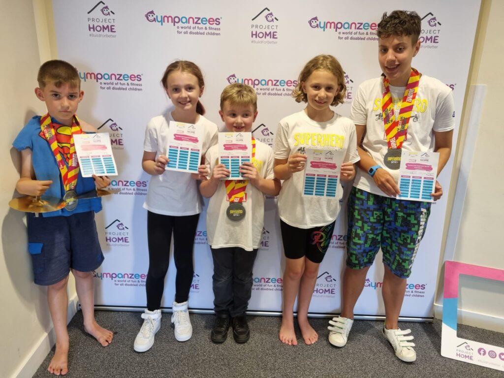 Children stood with certificates in front of a Gympanzees banner