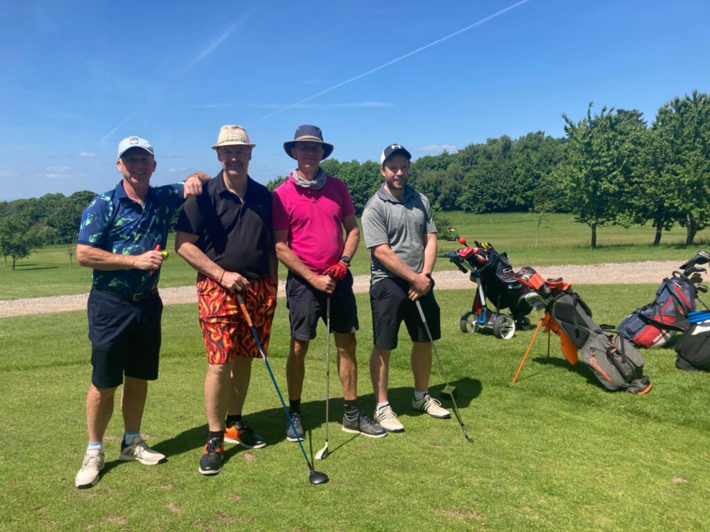 Four men stood for a photo on a golf course