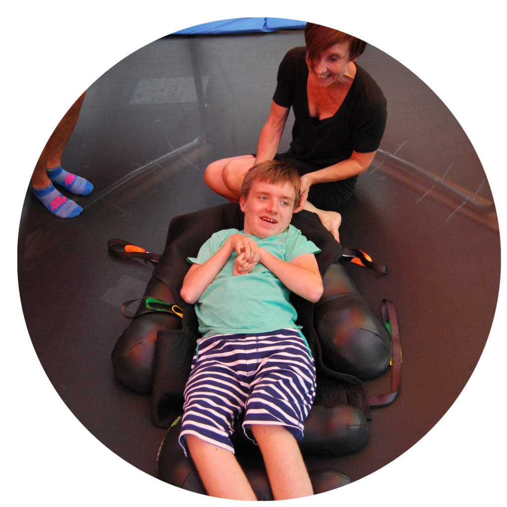 A boy laying on a trampoline with cushion supports