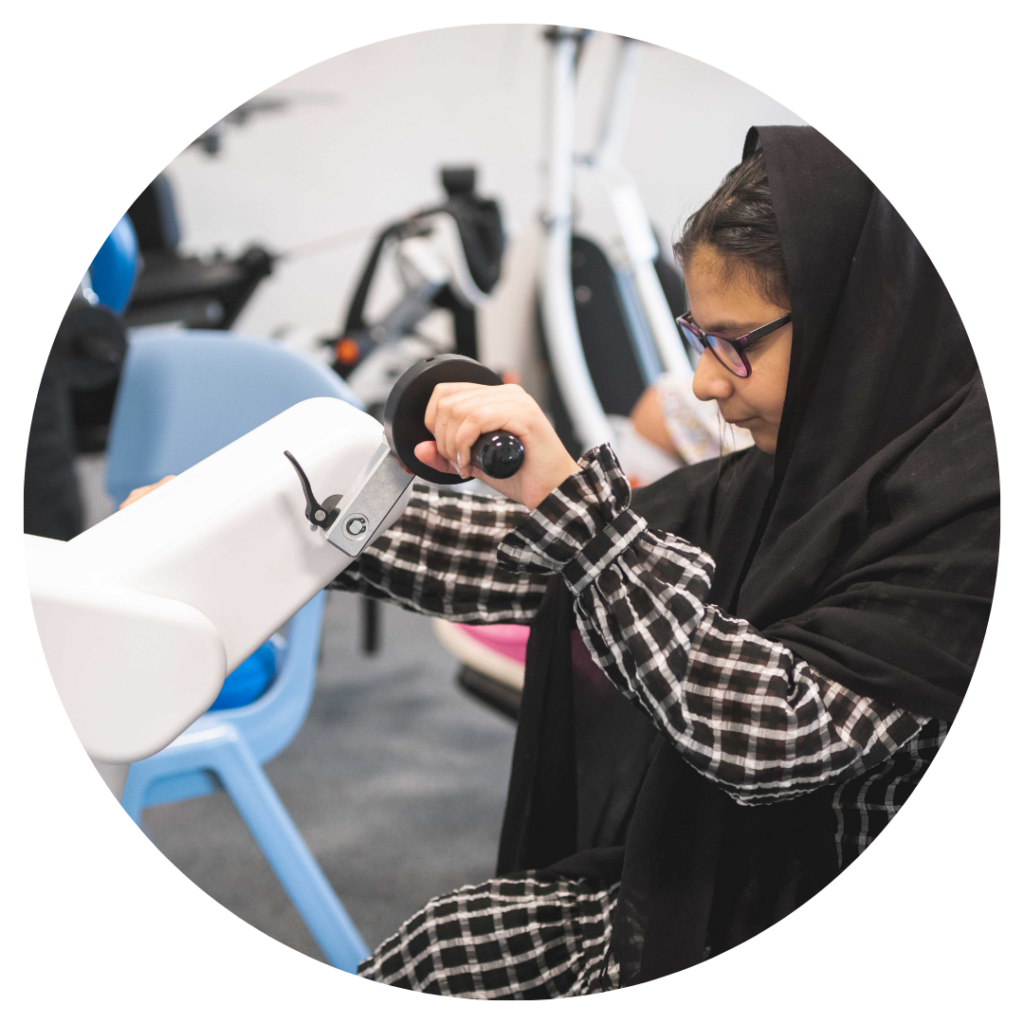 A young person using a motor med exercise machine