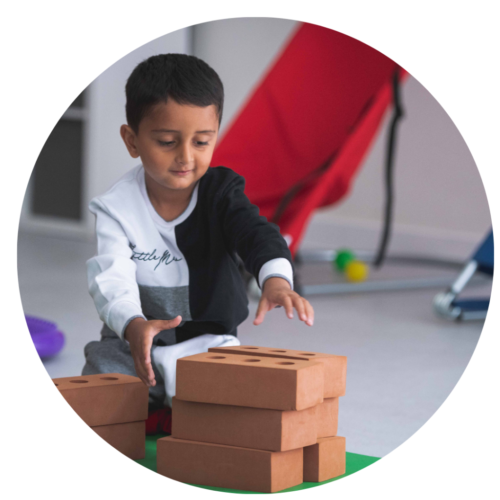 A young child stacking foam bricks