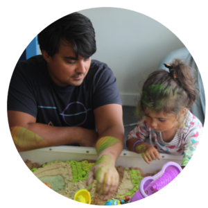 A parent and young child using an interactive sandpit