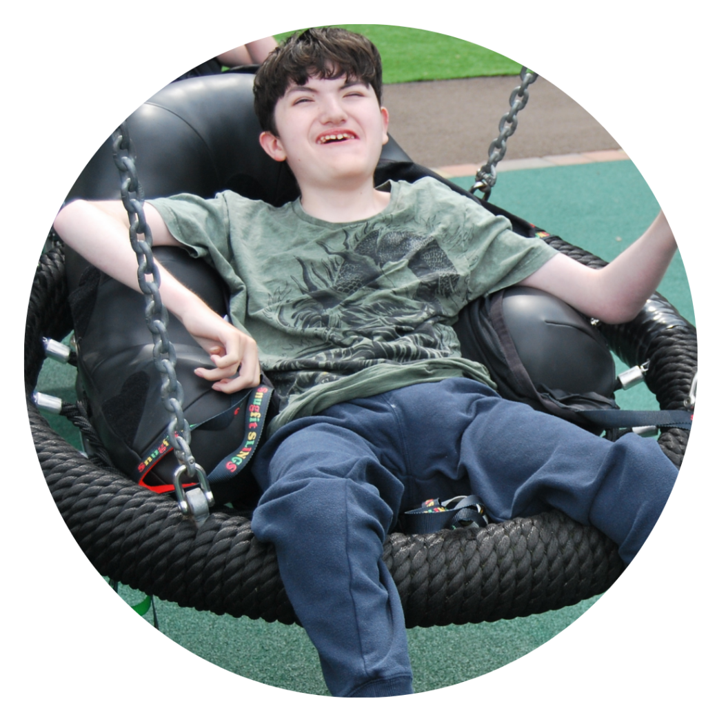 A boy swinging in an adapted swing