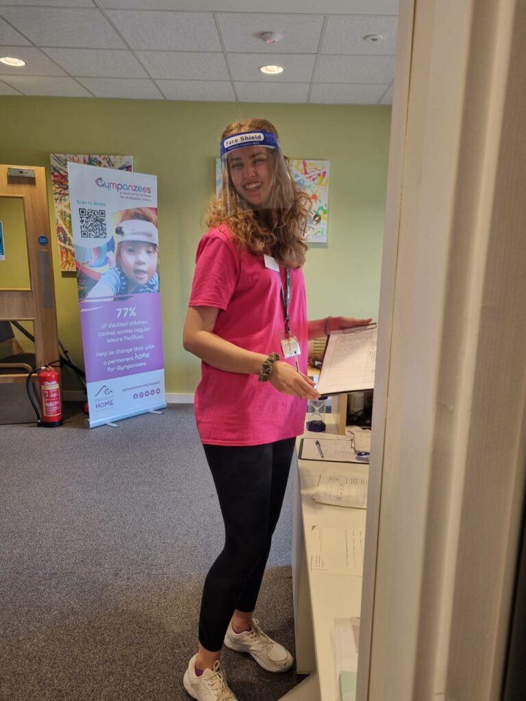 a woman in pink volunteer top smiling