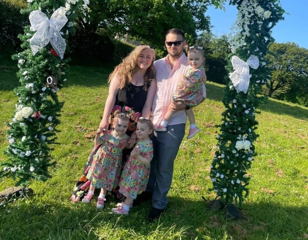 A family of five posing for a photo outdoors