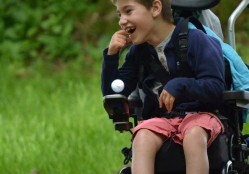 Child in a wheelchair outside.